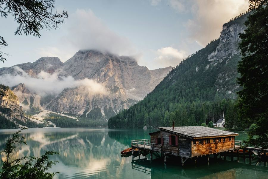 Boathouse on a calm alpine lake at dawn